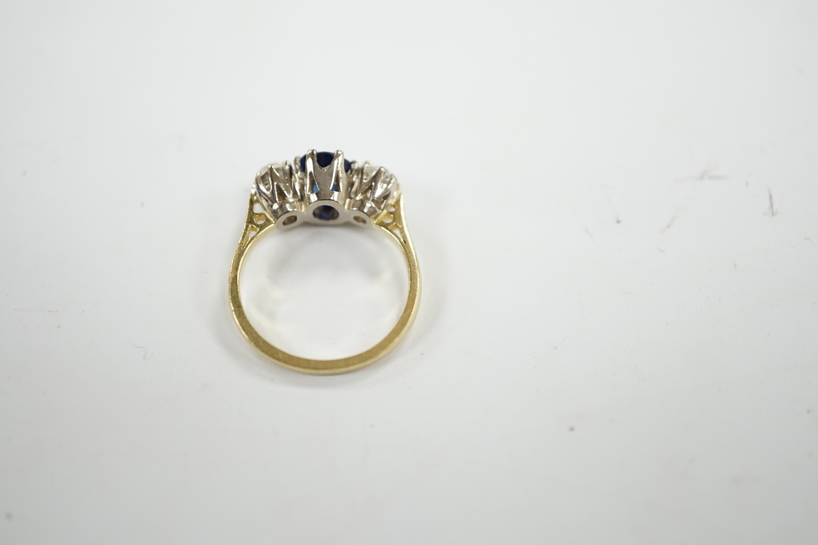 A late 1970's 18ct gold, sapphire and diamond set three stone ring, size J/K, gross weight 3.8 grams. Condition - fair